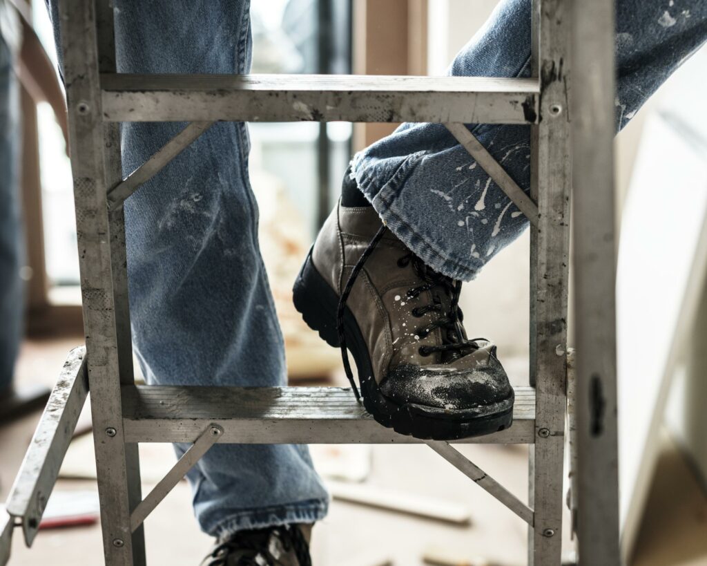 pies con botas de trabajo subiendo una escalera durante reformas integrales de viviendas